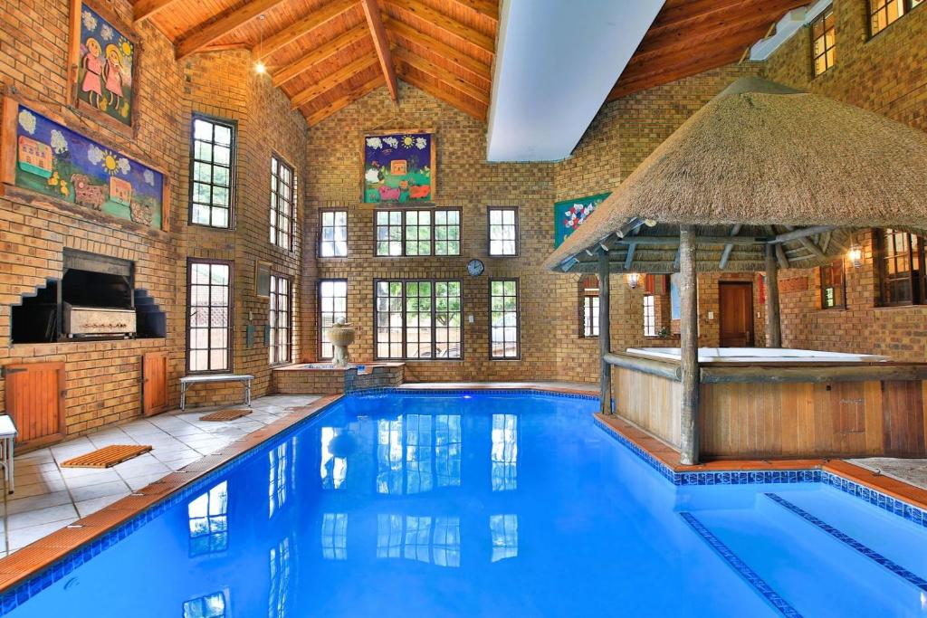 a large swimming pool with a bar in a building at Mereke Manor in Centurion
