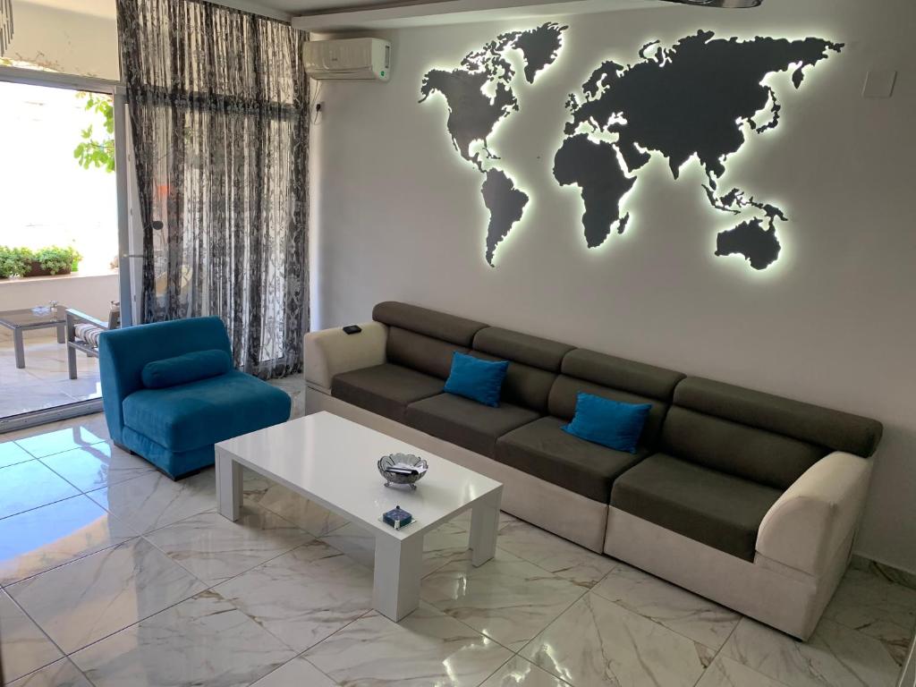 a living room with a couch and a world map on the wall at Sound of the Sea Apartment in Sveti Stefan