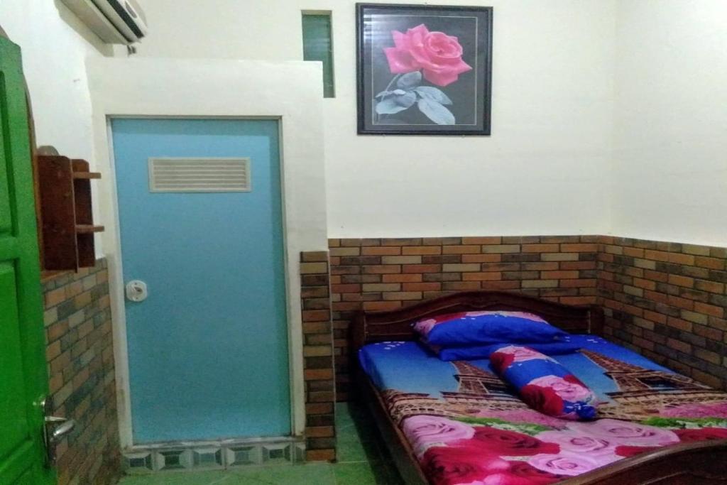 En eller flere senge i et værelse på SPOT ON 93946 Wisma Kost & Penginapan Afilia Buana Syariah