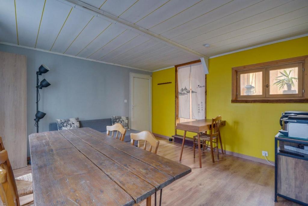 comedor con mesa de madera y paredes amarillas en Maison avec terrasse & parking Bordeaux Bacalan, en Burdeos