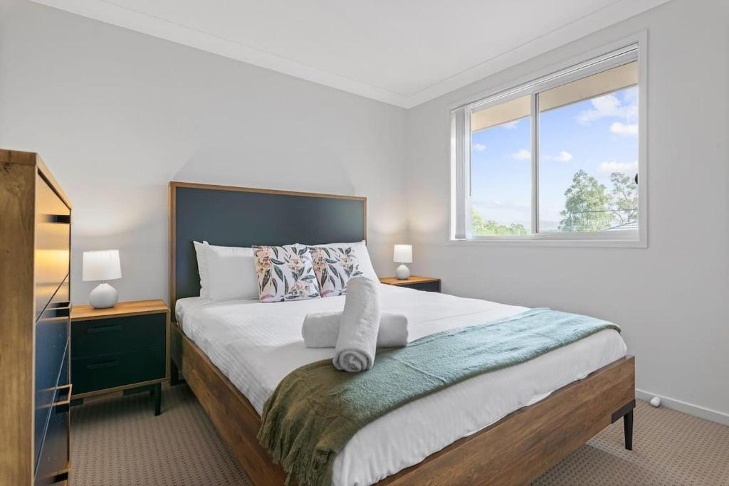Un dormitorio con una cama grande y una ventana en Hunter Explorer - Games Room & Spa, en Cessnock