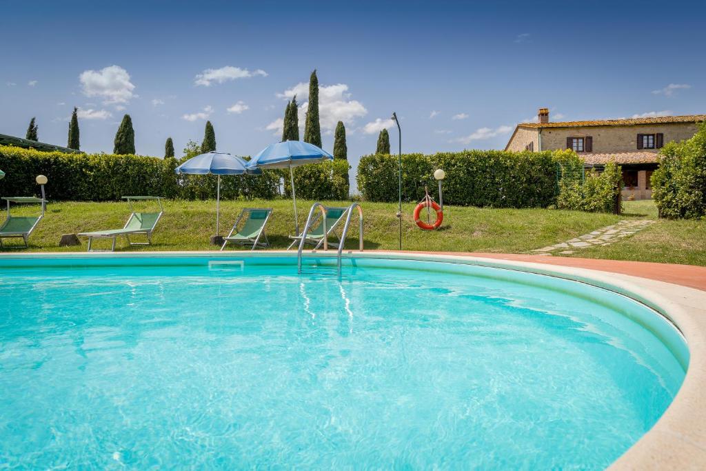 uma grande piscina com duas cadeiras e guarda-sóis em Santa Lina - Lavanda em Pomarance