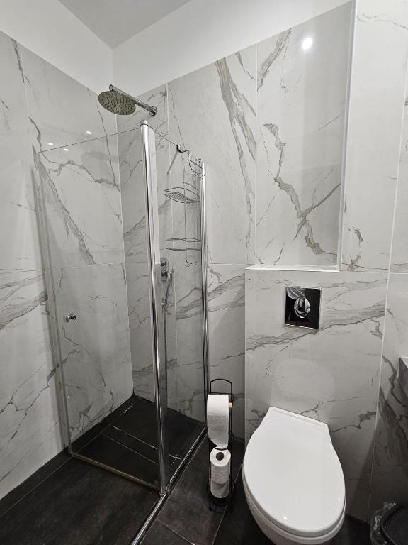 a white bathroom with a shower and a toilet at Sun Sea Center in Eilat