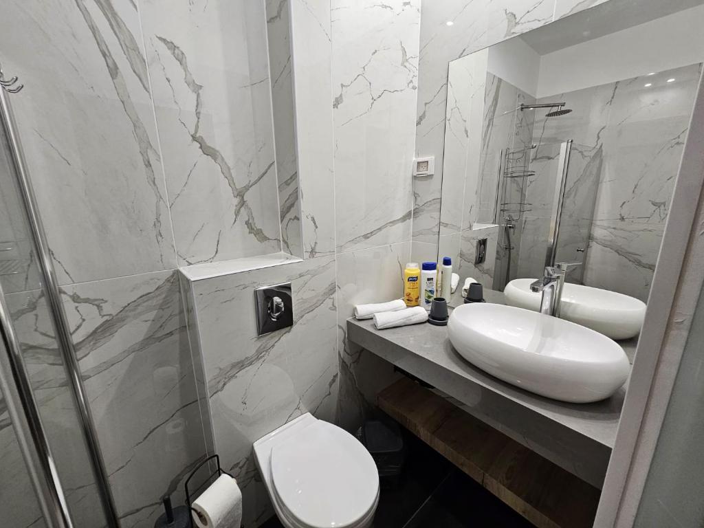 a bathroom with a sink and a toilet and a mirror at Sun Sea Center in Eilat