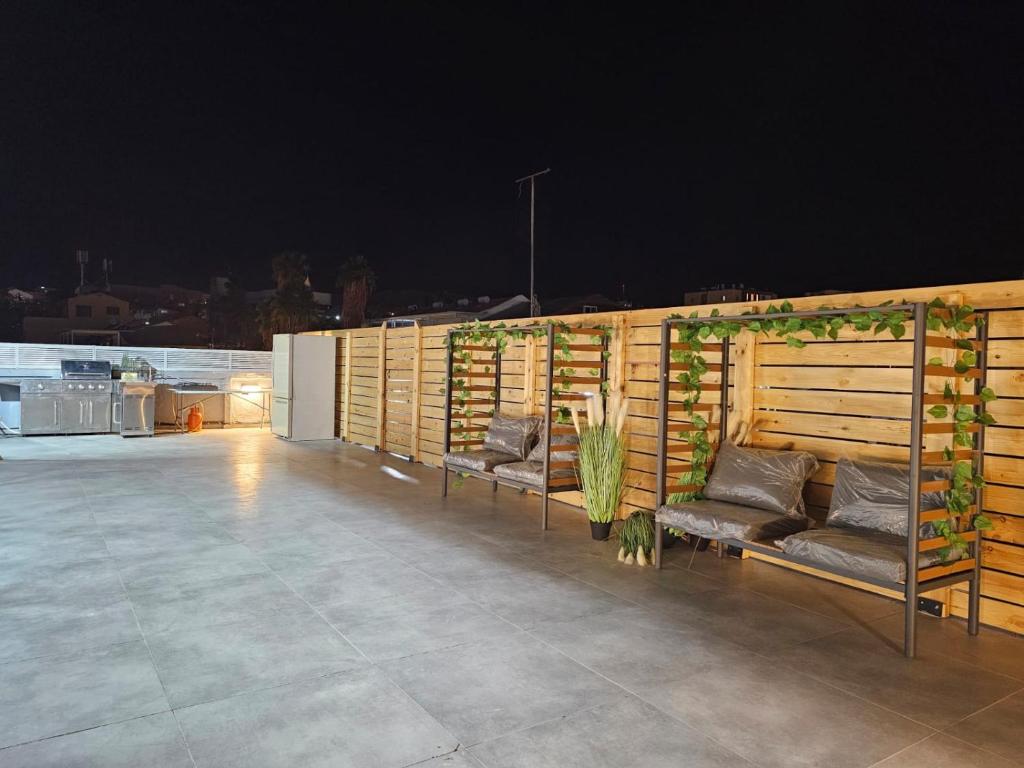a patio with benches on the roof at night at Sun Sea Center in Eilat