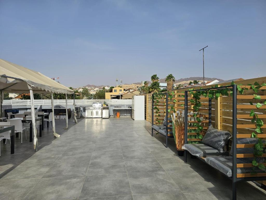 eine Terrasse mit Tischen und Stühlen auf dem Dach in der Unterkunft Sun Sea Center in Eilat