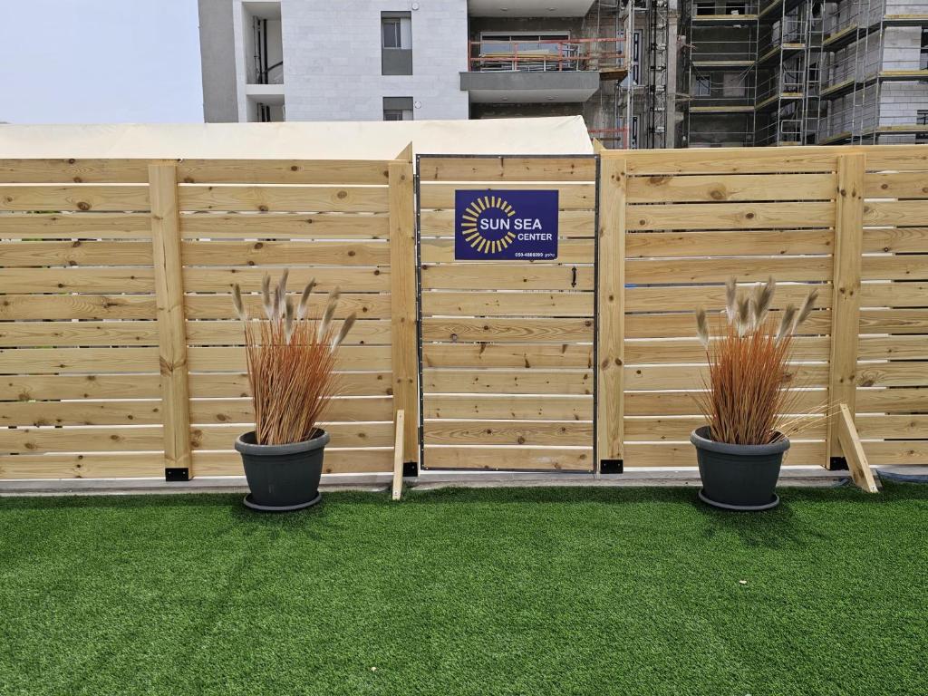 two potted plants in front of a wooden fence at Sun Sea Center in Eilat