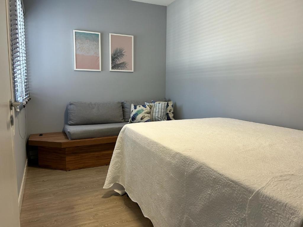 a bedroom with a bed and a couch at Apto 28A - Residencial Palladium Centro, Penha SC in Penha