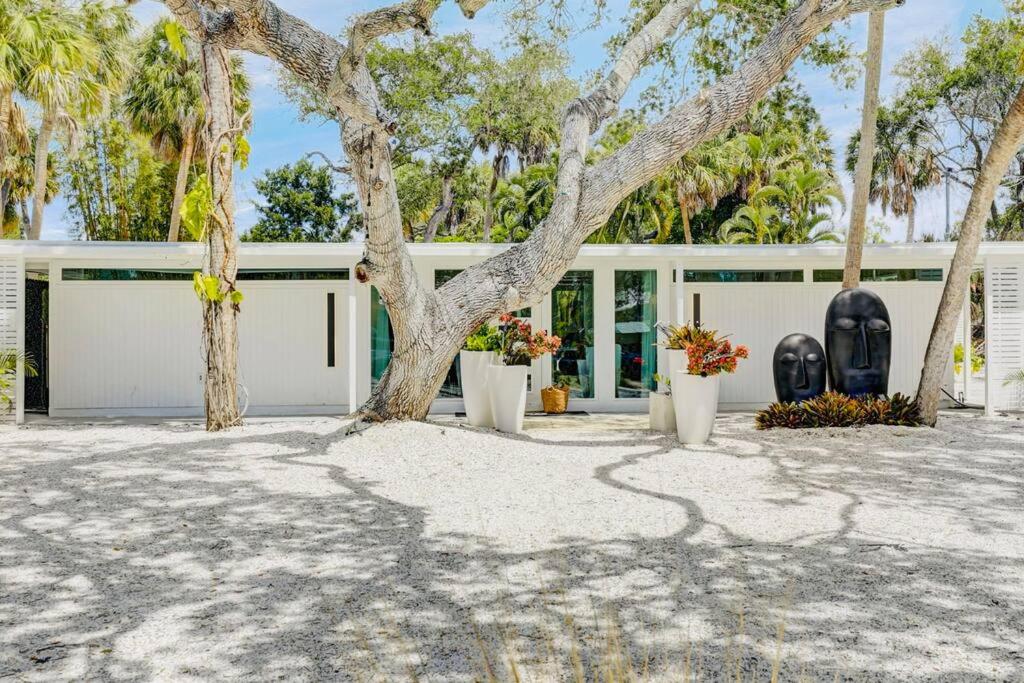 Una casa blanca con un árbol delante. en Zachs Siesta Key Beach House Pet Friendly, en Siesta Key