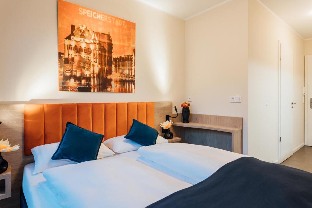 ein Schlafzimmer mit einem großen weißen Bett mit blauen Kissen in der Unterkunft MYKY Hotel Boardinghouse in Hamburg