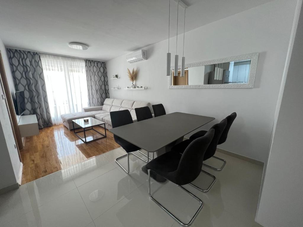 a dining room with a table and black chairs at New apartment near Split with garage in Solin