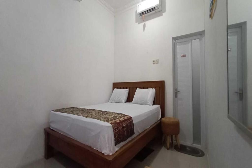 um quarto com uma cama num quarto branco em OYO 93963 Homestay Kita Purworejo em Purworejo