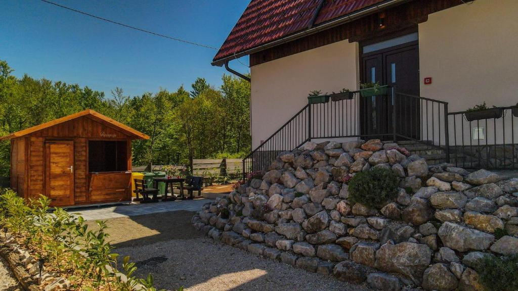a pile of rocks in front of a house at PLITVICKA KUCA M - Holiday Lodge in Plitvička Jezera