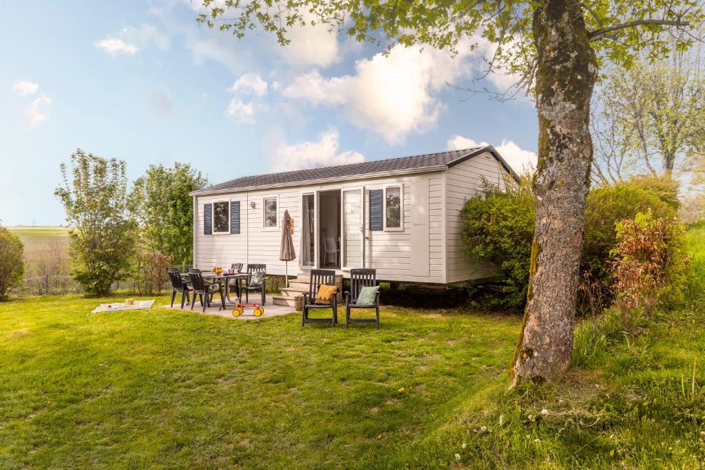una casetta minuscola con tavolo e sedie in cortile di Ardennen Camping Bertrix a Bertrix
