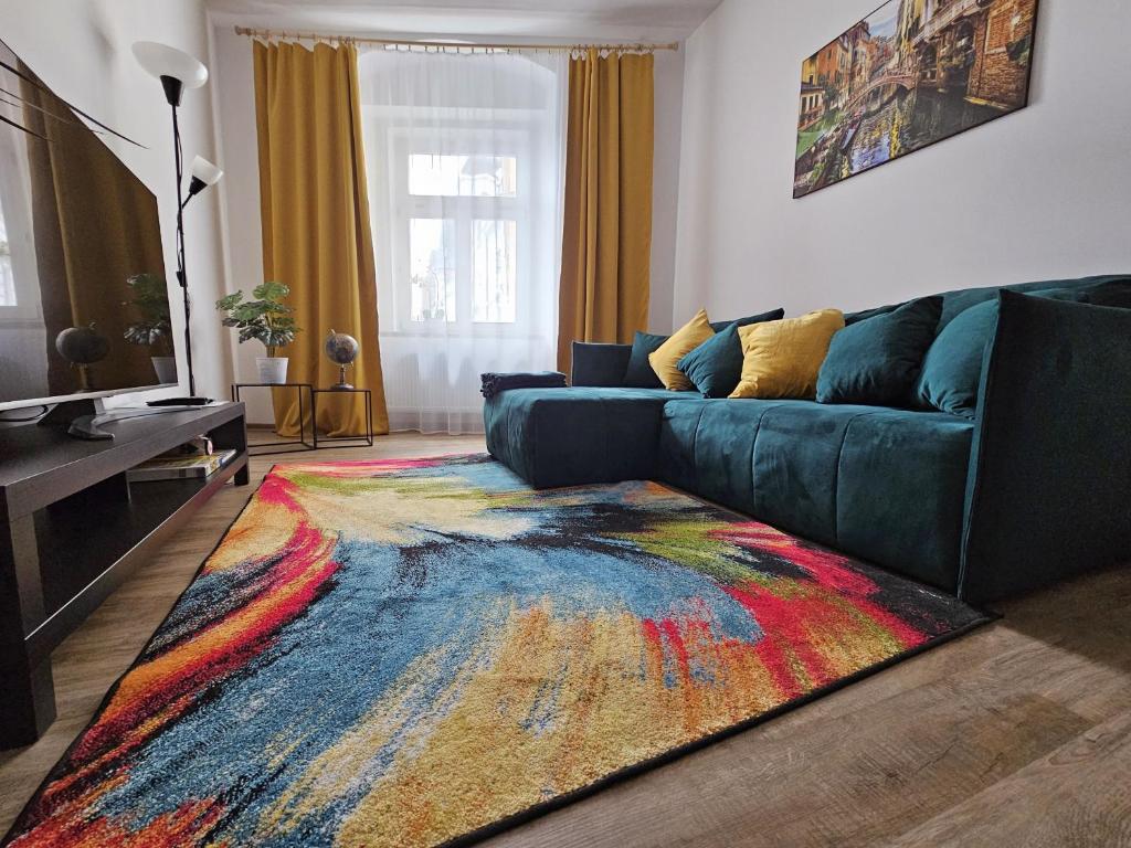 a living room with a couch and a colorful rug at Stylový byt v srdci Hradce Králové in Hradec Králové