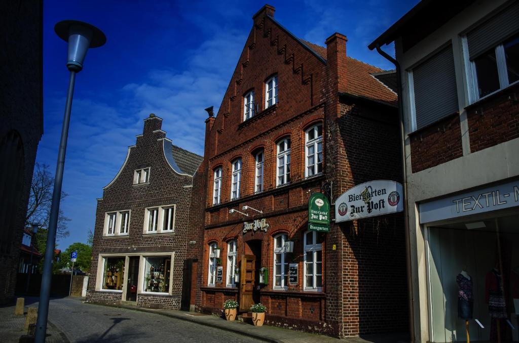 un antiguo edificio de ladrillo en una calle de la ciudad en Hotel Gasthof Zur Post, en Albersloh