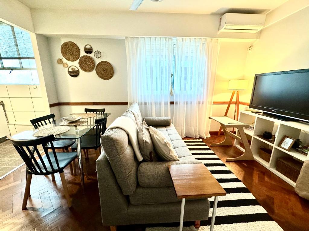 sala de estar con sofá y mesa en Renovado departamento en el corazón de la ciudad en Buenos Aires