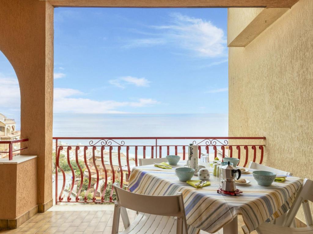 a table on a balcony with a view of the ocean at Apartment Il Poggio by Interhome in Letojanni