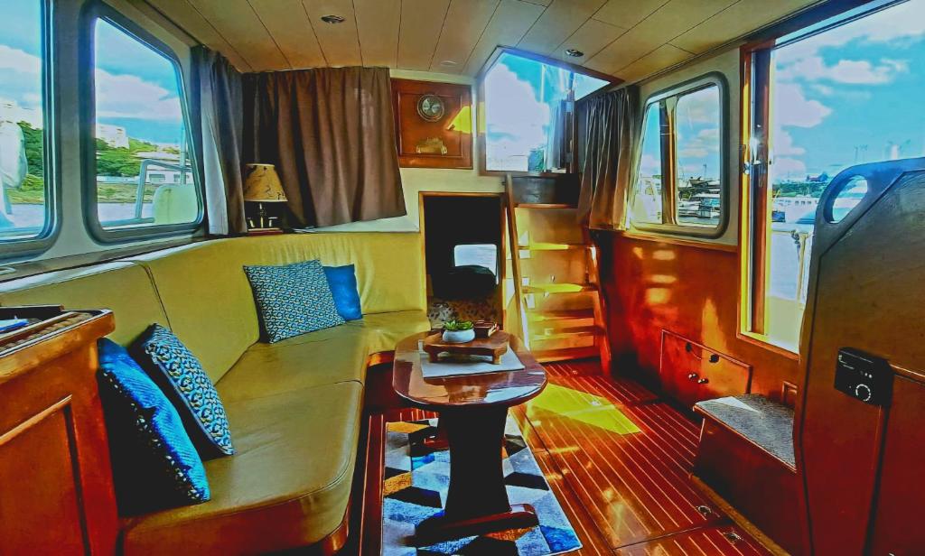 a living room with a table in a train car at Bateau le Zimon - logement insolite in Rouen