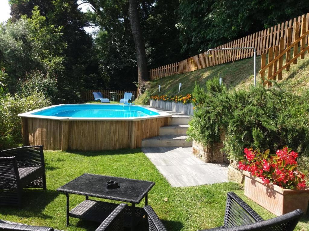 a pool in a yard with a table and chairs at Residence Rossini in Tavernerio