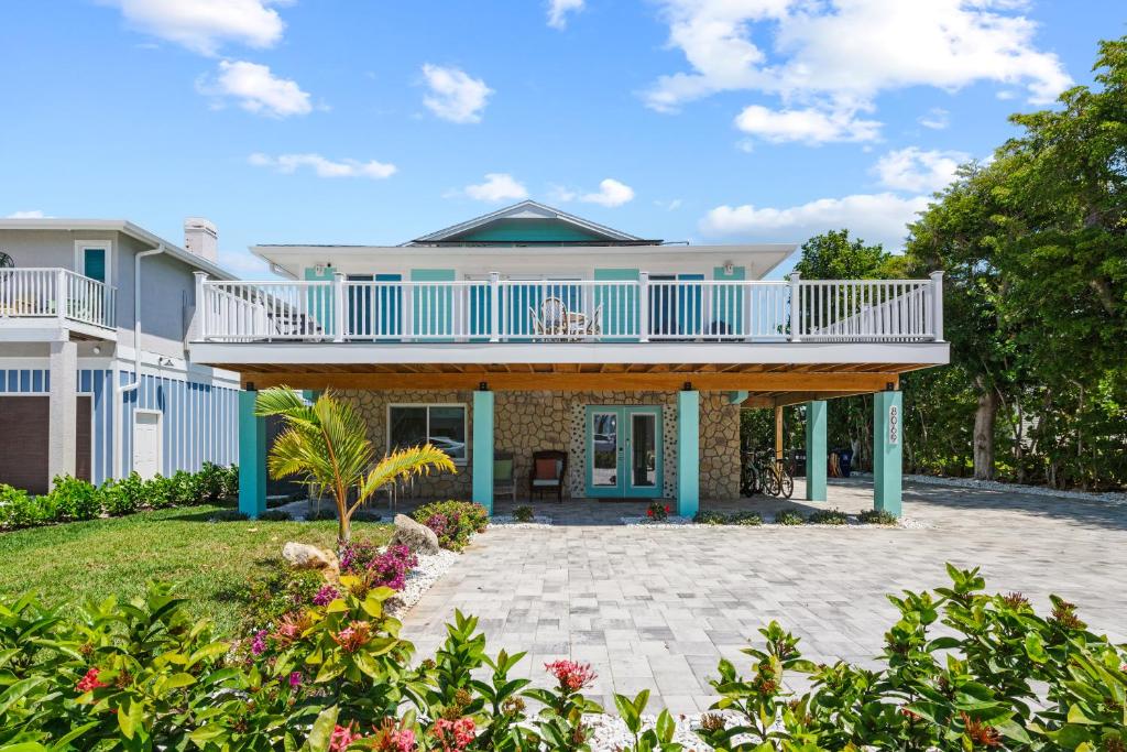 een groot huis met een balkon en een tuin bij Go to the beach from expansive heated pool home in Fort Myers Beach
