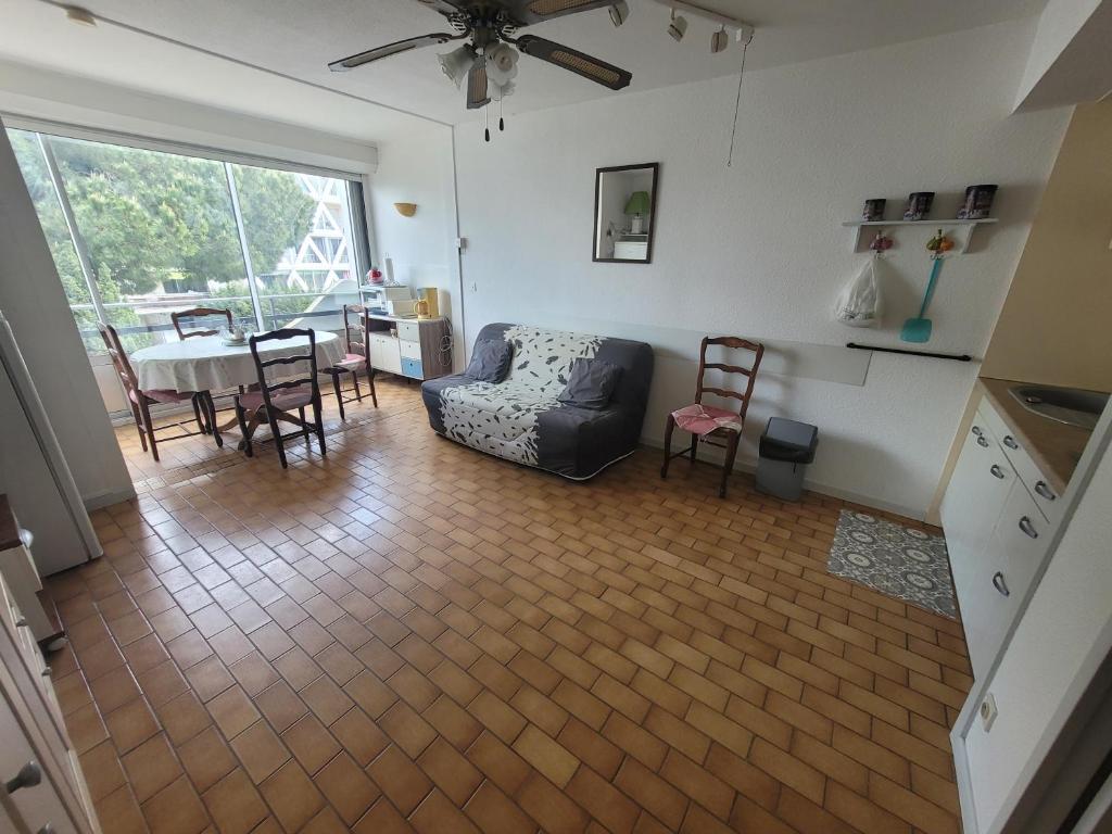 ein Wohnzimmer mit einem Sofa und einem Tisch in der Unterkunft Studio cabine au centre ville à 150m de la plage N1 66 in La Grande-Motte