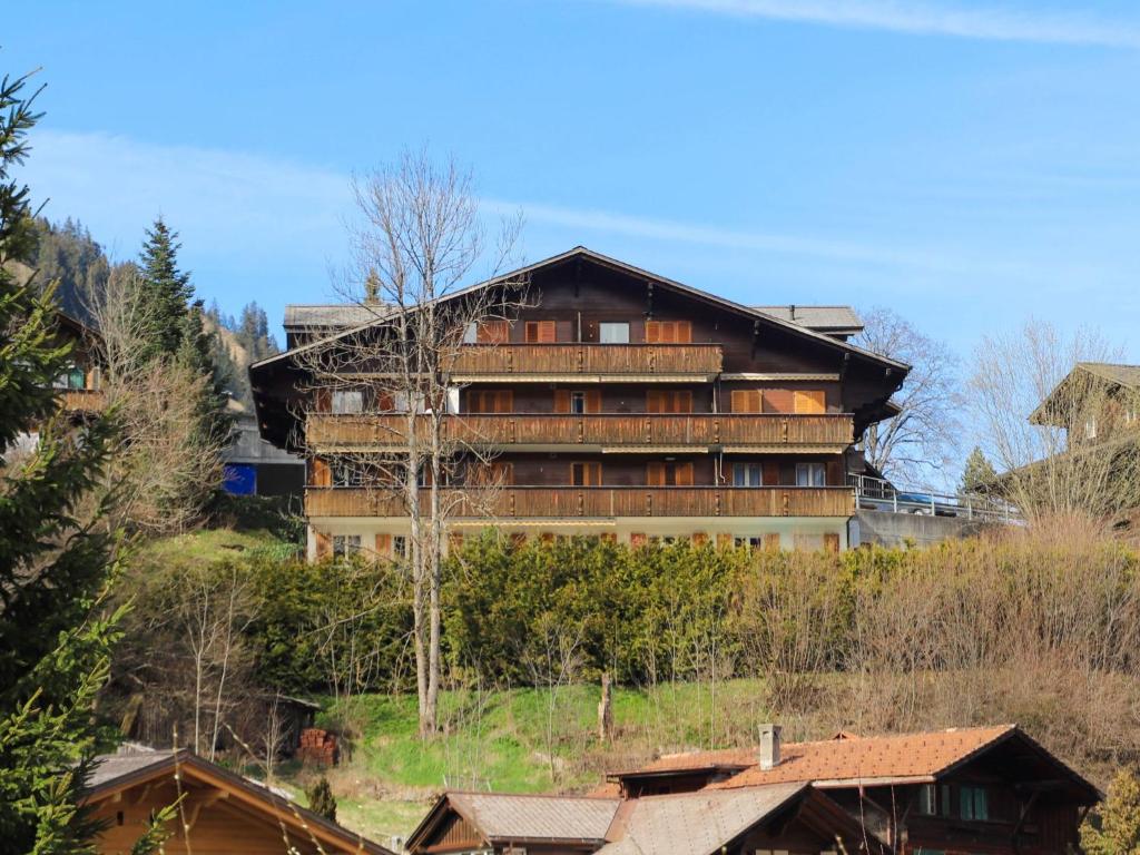 ein großes Gebäude auf einem Hügel mit Häusern in der Unterkunft Apartment Belmi by Interhome in Zweisimmen