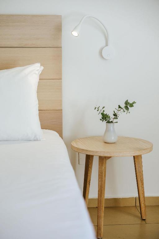 a table with a vase on it next to a bed at Nissi Park Hotel in Ayia Napa