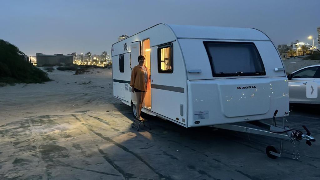 a man standing in front of a white trailer at Hilazon Caravan in Ashdod