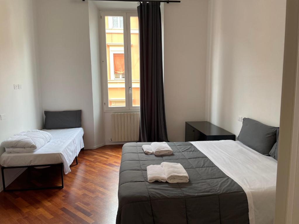 una camera con due letti e una finestra di whouse large suite apartment indipendenza a Bologna