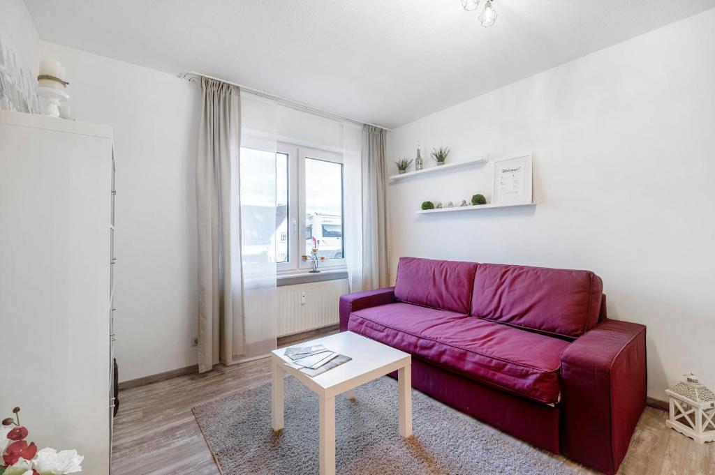 ein Wohnzimmer mit einem lila Sofa und einem Tisch in der Unterkunft Fewo Nele in Gries