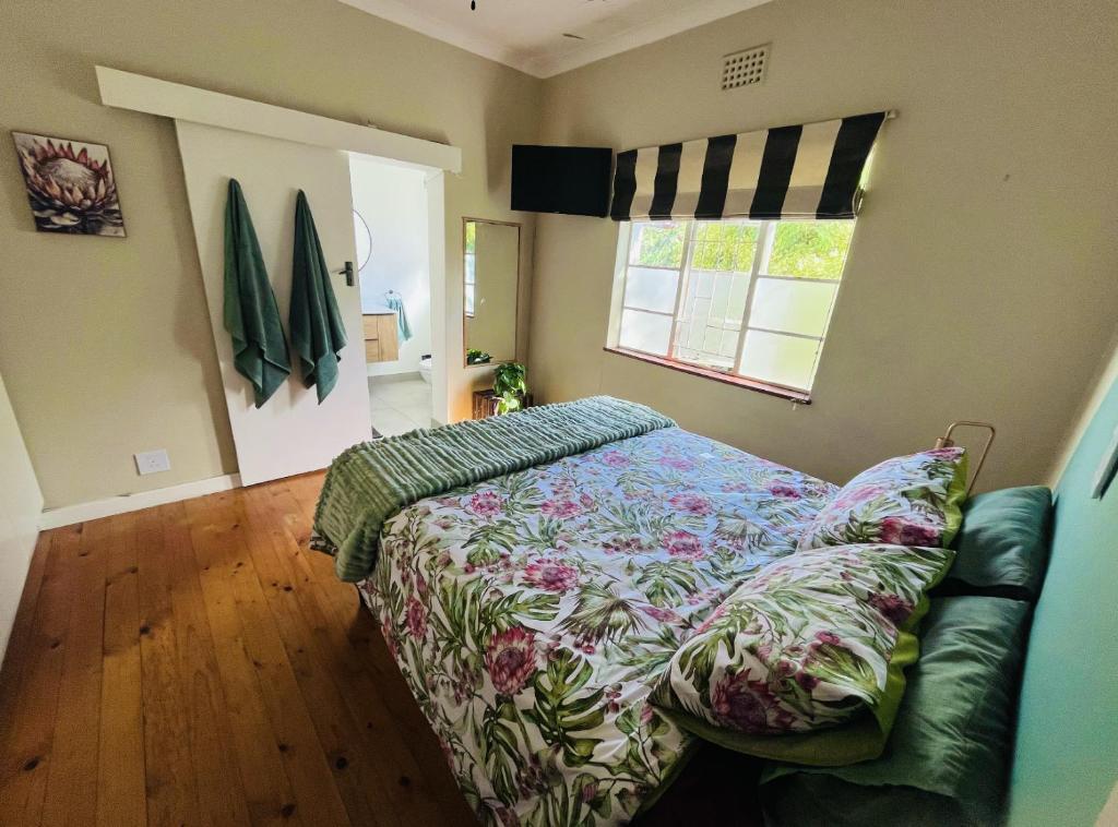1 dormitorio con cama y sofá en Rondebosch Cottage, en Ciudad del Cabo