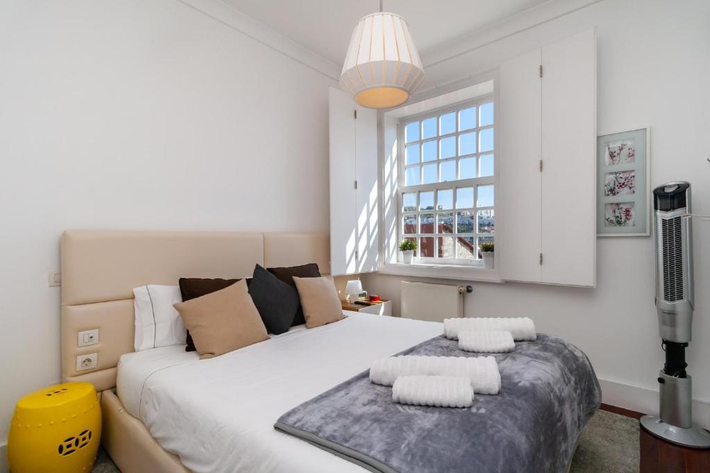 Un dormitorio con una gran cama blanca y una ventana en GuestReady - Ribeira Apt in Porto center en Oporto