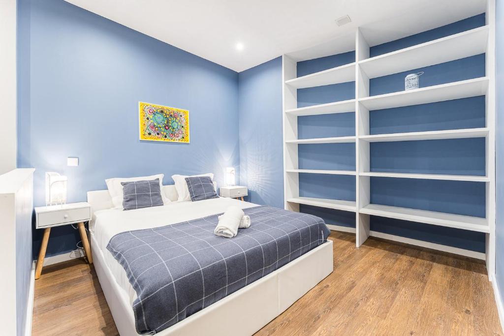 ein Schlafzimmer mit blauen Wänden und ein Bett mit einer Katze drauf in der Unterkunft GuestReady - The New Lazuli Flat in Porto