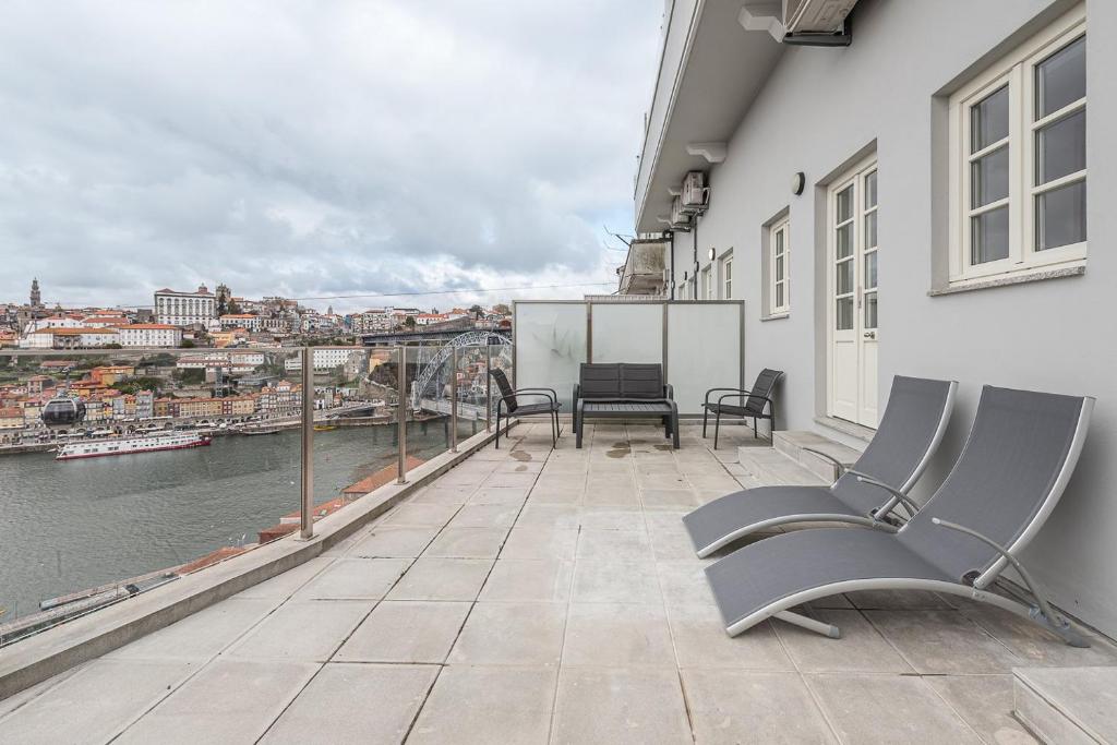 d'un balcon avec des chaises et une vue sur l'eau. dans l'établissement GuestReady - Riverview Douro Terrace, à Vila Nova de Gaia