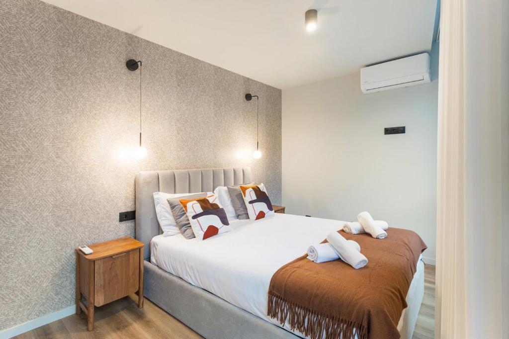 a bedroom with a large bed with towels on it at GuestReady - Khaki Roof in Santo Ovídio