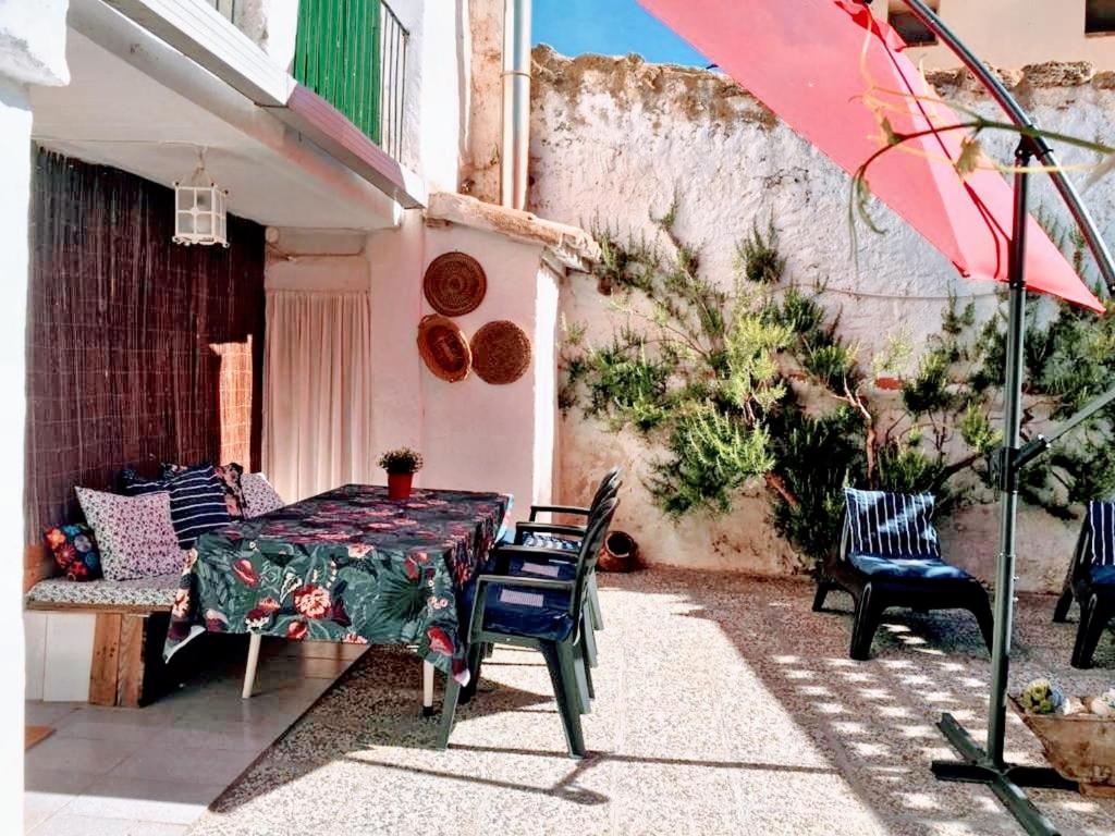 un patio con mesa, sillas y sombrilla en 3 bedrooms house with enclosed garden and wifi at El Poyo del Cid, en El Poyo