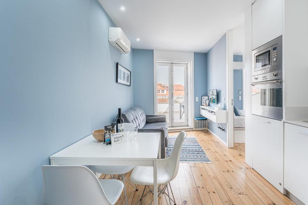 uma cozinha e sala de estar com uma mesa branca e cadeiras em GuestReady - The Other Side no Porto