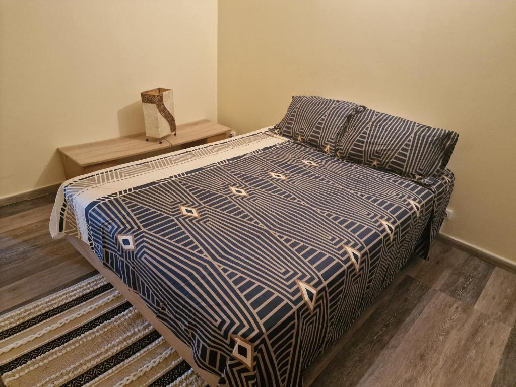 uma cama com um edredão azul e branco num quarto em duplex moderne direct aéroport em Les Abymes