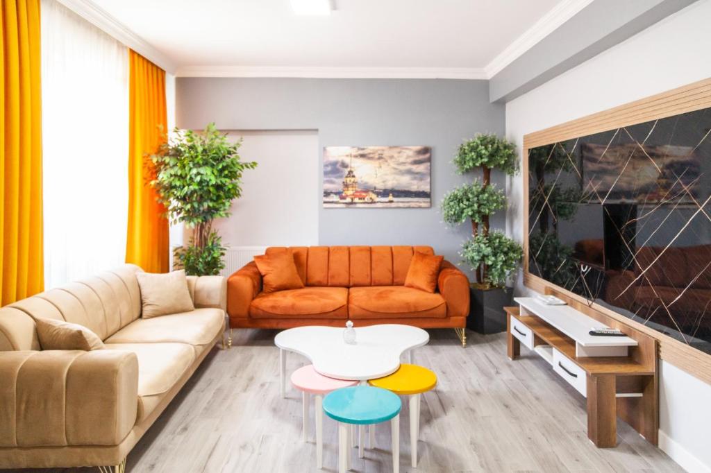 a living room with an orange couch and a table at MİMOZA BUSİNESS PLUS apart in Sanlıurfa