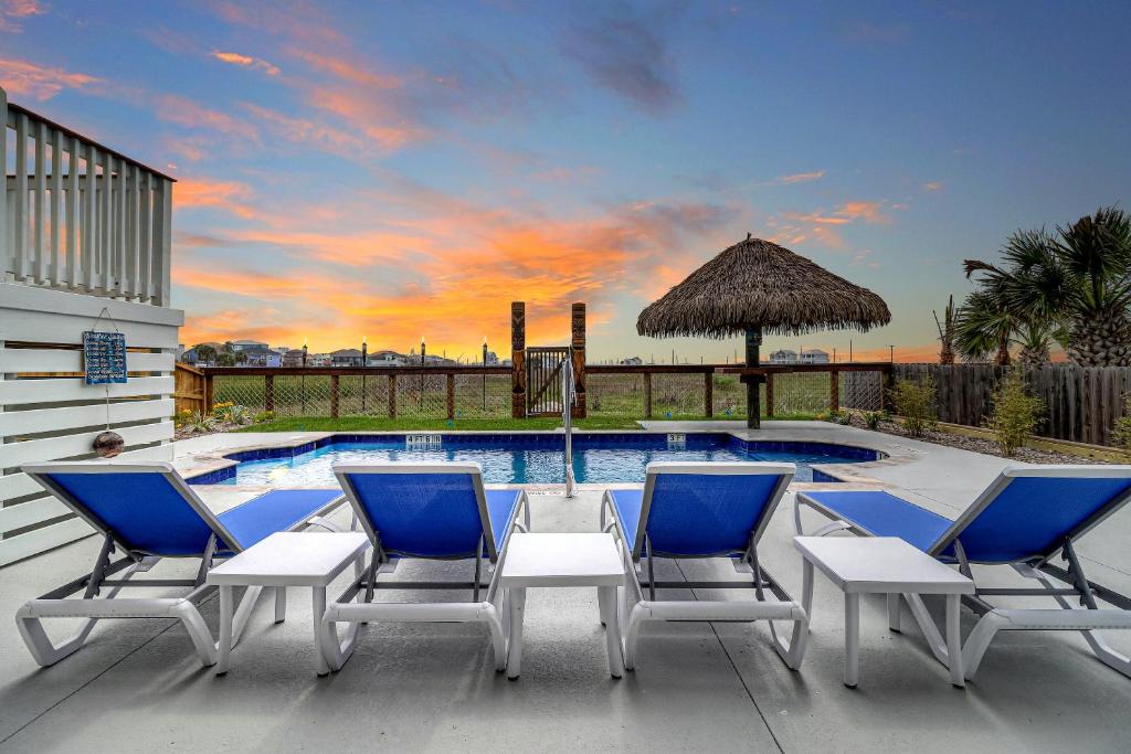 a group of chairs sitting next to a swimming pool at Casa De Coconuts in Padre Island