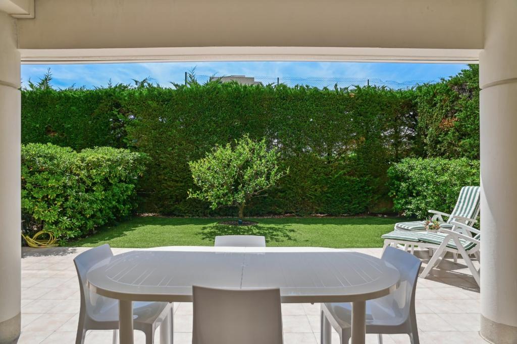une table blanche et des chaises sur une terrasse dans l'établissement Superbe appart Cannes bord de plage avec piscine, à Cannes