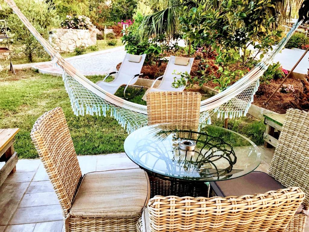 a hammock with chairs and a glass table and chairs at One bedroom house with shared pool enclosed garden and wifi at Vibo Valentia in Parghelia