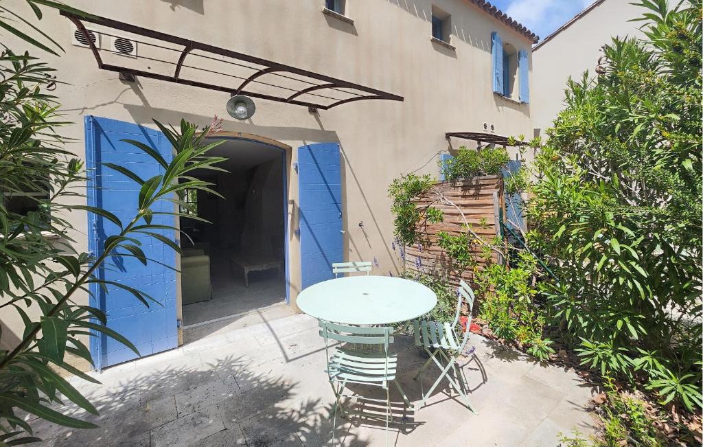 une table et des chaises devant un bâtiment avec une porte bleue dans l'établissement 2 Bedroom Nice Home In Saint-Laurent-De-La-Ca, à Saint-Laurent-de-la-Cabrerisse