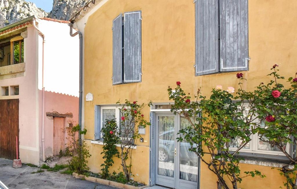 a yellow house with windows and a door at Awesome Home In Moustiers-Sainte-Marie in Moustiers-Sainte-Marie