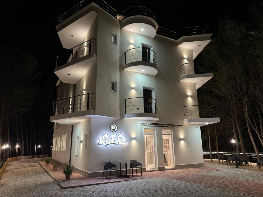 ein großes weißes Gebäude, das nachts beleuchtet ist in der Unterkunft Hotel Kseal in Përmet
