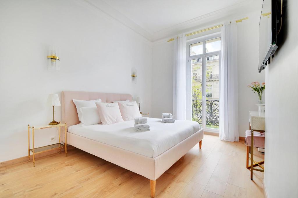 une chambre blanche avec un lit blanc et une fenêtre dans l'établissement Pick A Flat's Apartment in République - Avenue de la République, à Paris