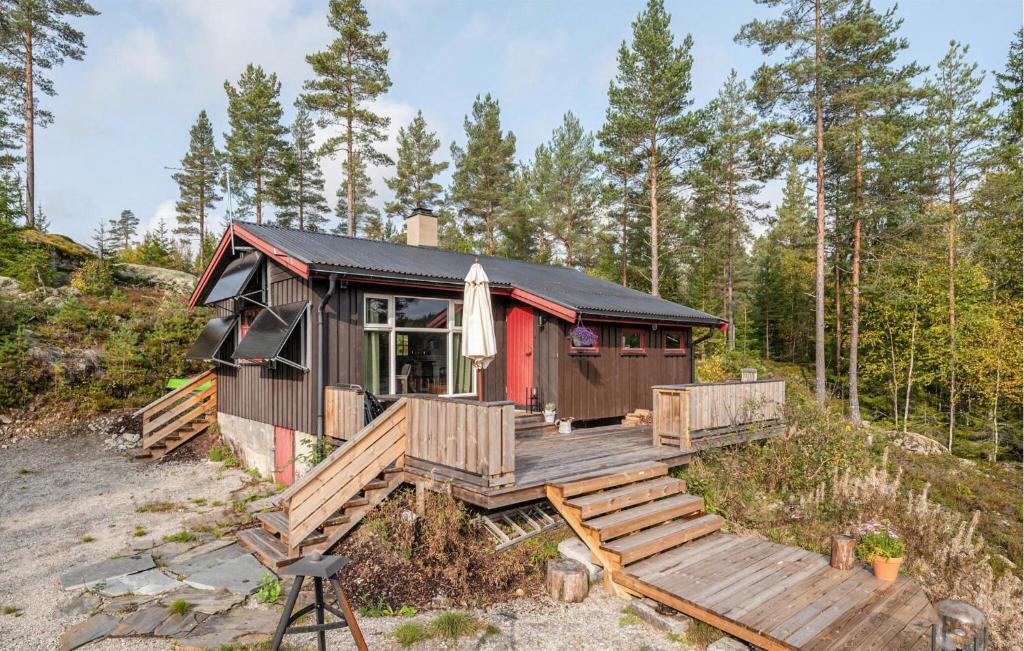 a tiny house with a deck in the woods at Stunning Home In Setskog With Lake View 