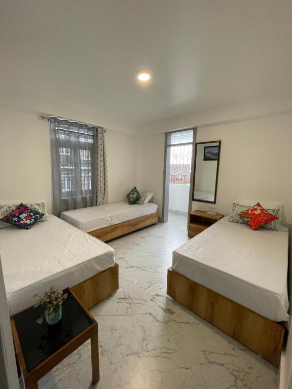 een kamer met 2 bedden en een spiegel bij Ga-Ki-Khim Homestay in Gangtok