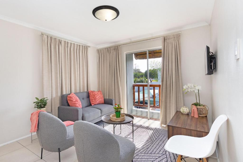 a living room with a couch and chairs and a table at Serengeti selfcatering apartments Perfect Stay in Bellville